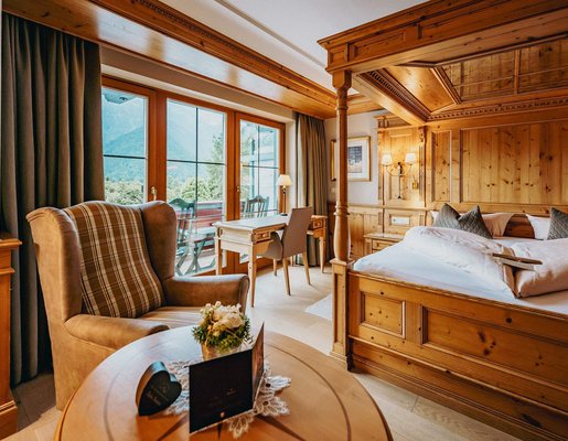 Hotelzimmer mit Himmelbett und viel Holz.