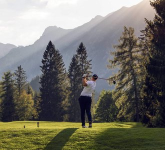 Ein Golfer schlägt einen Golfball ab.