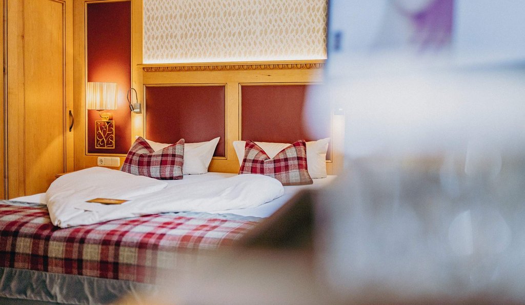 Blick auf ein Doppelbett mit herzförmig gelegter Bettwäsche.